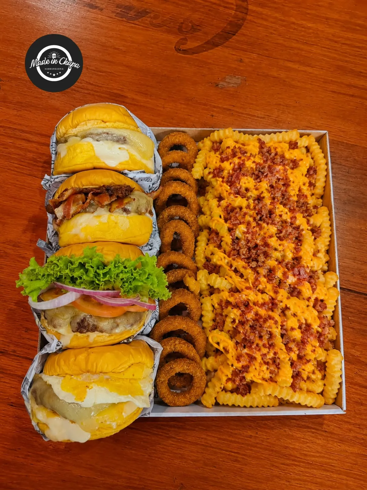 Bandeja com quatro hambúrgueres, batata com cheddar e bacon e anéis de cebola