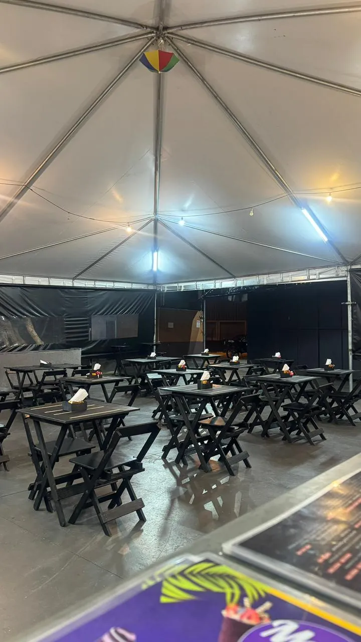 Vista do interior da tenda com luzes penduradas acesas